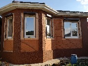 Углы и цоколь дома утеплен пенопластом. Отделка стен мраморной крошкой на завершающем этапе